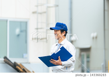 工場の前に立つ笑顔の男性作業員 143360283