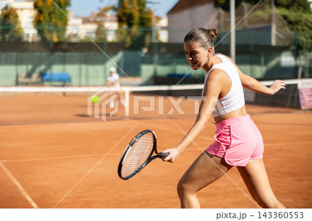 Young woman playing tennis against older woman Young woman playing tennis against older woman 143360553