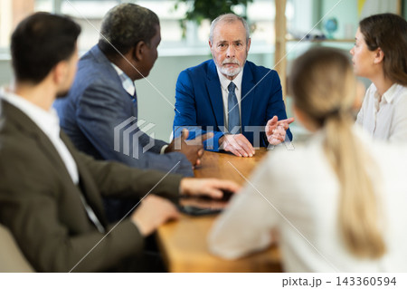 Representatives of business community sitting at table and chatting, talking, speaking Representatives of business community sitting at table and chatting, talking, speaking 143360594