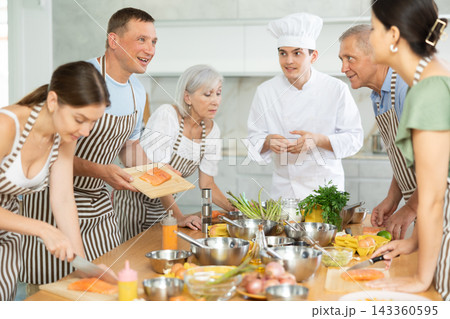 Cheerful man communicating friendly to participants of culinary class 143360595