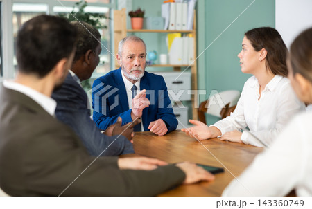 Representatives of business community sitting at table and chatting, talking, speaking Representatives of business community sitting at table and chatting, talking, speaking 143360749