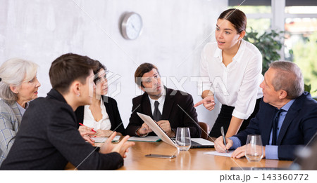 Young businesswoman discussing with colleagues during work meeting Young businesswoman discussing with colleagues during work meeting 143360772