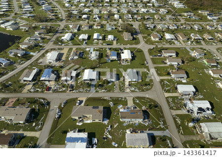 Consequences of natural disaster in Florida, USA. Aerial view of heavily damaged by hurricane Ian houses in mobile home residential area Consequences of natural disaster in Florida, USA. Aerial view of heavily damaged by hurricane Ian houses in mobile home residential area 143361417