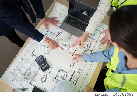 Architects and civil engineers reviewing building blueprint during project meeting Architects and civil engineers reviewing building blueprint during project meeting 143362058