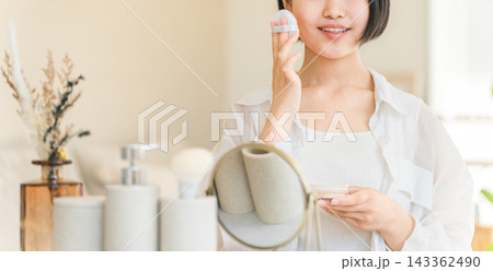 鏡を見ながらフェイスパウダーをつける10代の若い女の子 鏡を見ながらフェイスパウダーをつける10代の若い女の子 143362490