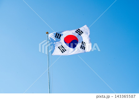 South Korean Flag (Taegeukgi) Waving Against a Clear Blue Autumn Sky 143365587