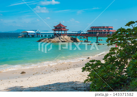 Tropical beach view with bridge, pagoda, rocks, and blue ocean on Pirate Island Wuzhizhou in Sanya Hainan. Summer travel destination Tropical beach view with bridge, pagoda, rocks, and blue ocean on Pirate Island Wuzhizhou in Sanya Hainan. Summer travel destination 143371582