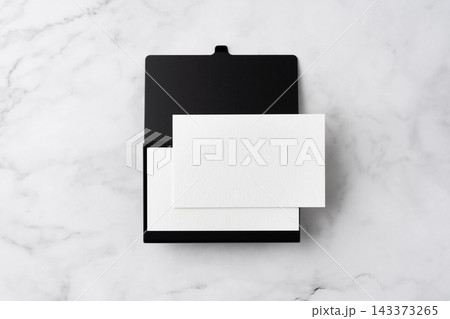 Blank white business cards and open black aluminum card holder on white marble background, top view flat lay with copy space 143373265