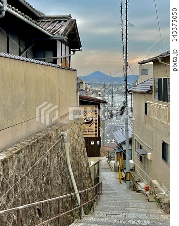 坂の街・尾道の急な石段と家並み 隙間から望む街と山影 143375050