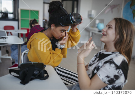 High school student using virtual reality for immersive learning in classroom. 143375070
