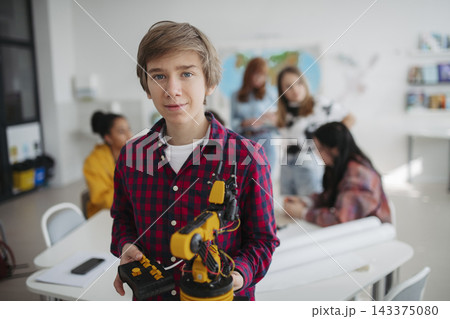Teen student studying robotics while preparing for further education. 143375080
