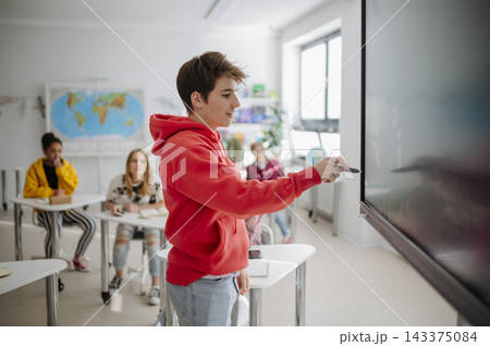 Teen student working together on interactive digital board at school. Teen student working together on interactive digital board at school. 143375084