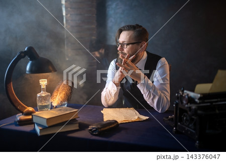 Pensive author sitting at his classic writing table Pensive author sitting at his classic writing table 143376047