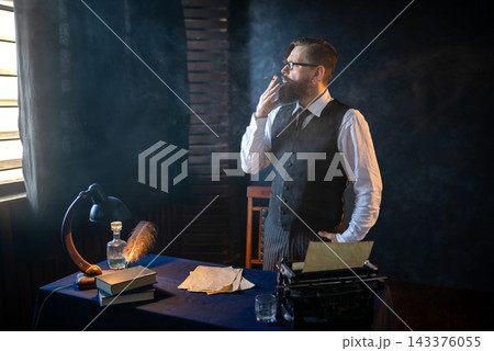 Thoughtful writer smoking a cigar near his workspace 143376055