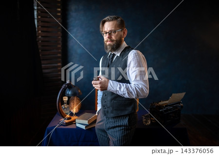 Intellectual man smoking a classic pipe by the window 143376056