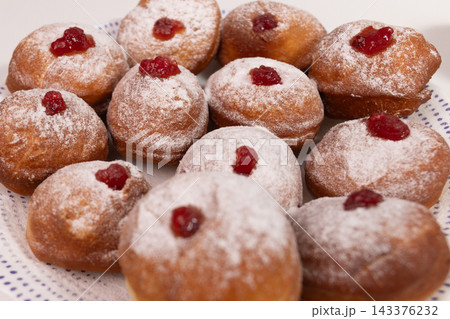 Close up of homemade sufganiyot with jam and powdered sugar Close up of homemade sufganiyot with jam and powdered sugar 143376232