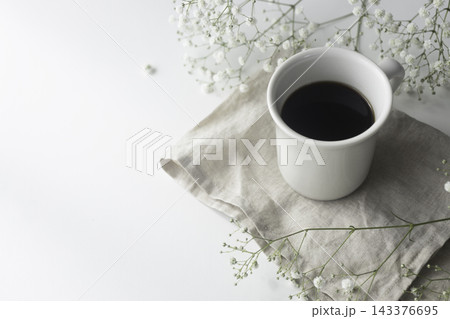 白いかすみ草とブラックコーヒーのあるナチュラルなテーブル 白いかすみ草とブラックコーヒーのあるナチュラルなテーブル 143376695