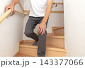 階段の途中で手すりにつかまり膝に手を当て痛がる人 143377066