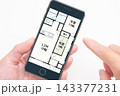 住宅（戸建て、マンション、アパート）の間取り図をスマホでチェックする人の手元 143377231
