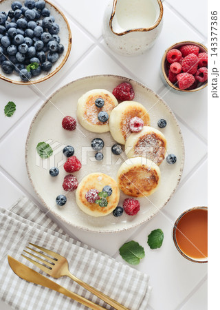 Cottage cheese pancakes with fresh blueberries, raspberries and mint on a plate Cottage cheese pancakes with fresh blueberries, raspberries and mint on a plate 143377386