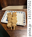 皿に盛られた香ばしい焼き鳥（鶏皮）2本 143377502