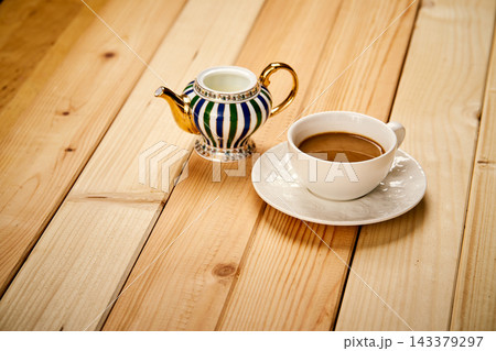 Small cup with aromatic coffee with milk on wooden table Small cup with aromatic coffee with milk on wooden table 143379297