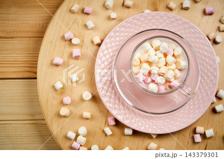 Cup with hot milk and colorful marshmallows on wooden table Cup with hot milk and colorful marshmallows on wooden table 143379301