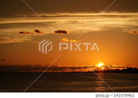 夕日に染まる海と港のシルエット 夕日に染まる海と港のシルエット 143379461
