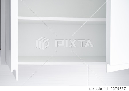 Empty kitchen cupboard with clean white shelves 143379727