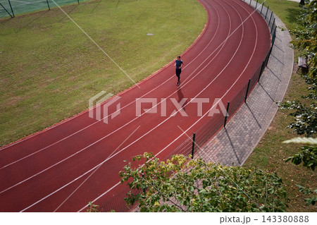 Woman running on stadium track, aerial view Woman running on stadium track, aerial view 143380888