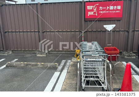 駐車場に設置されたショッピングカート置き場と並んだ買い物カート 143381375