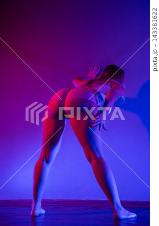 Young woman twerking in neon light. Young woman twerking in neon light. 143381622