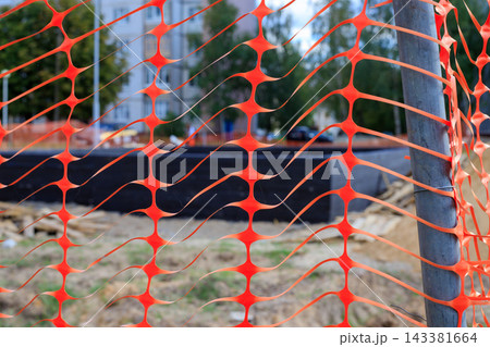 Orange Plastic Safety Net Barrier Around Construction Site for Danger Caution Concept 143381664