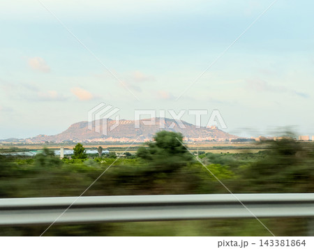 Cullera mountain with town name letters seen from highway with blurred trees and guardrail Cullera mountain with town name letters seen from highway with blurred trees and guardrail 143381864