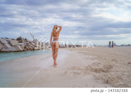 Woman stretching arms on a beach Woman stretching arms on a beach 143382388
