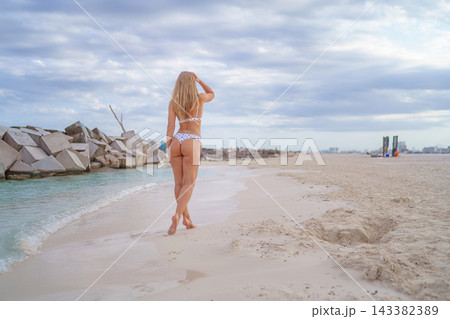 Woman stretching arms on a beach Woman stretching arms on a beach 143382389