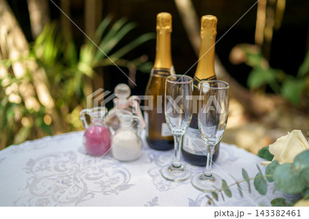 Two sparkling wine bottles and flutes on wedding ceremony table 143382461
