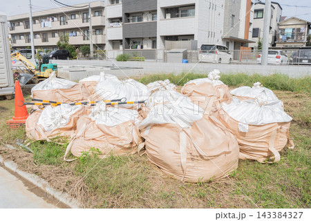 住宅建設現場の造成地に置かれた大量のフレコンバッグ 住宅建設現場の造成地に置かれた大量のフレコンバッグ 143384327