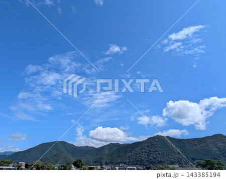 青空と白い雲が広がる緑豊かな山里の風景 143385194