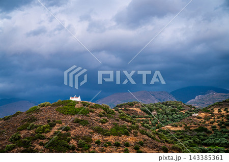 Small white chapel beneath storm clouds, eastern Crete, Greece 143385361