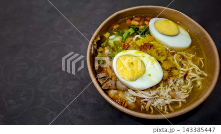 Indonesian Chicken Porridge Bubur Ayam with Hard Boiled Egg in Paper Bowl    143385447
