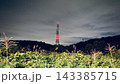赤い航空障害灯が光る送電鉄塔と夜の田園風景 143385715