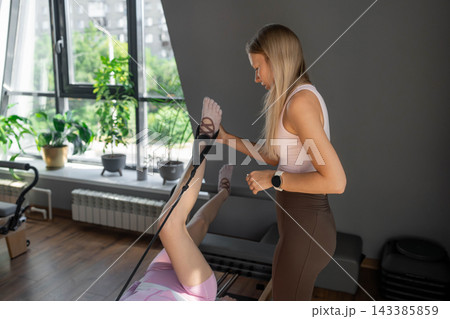 A detailed closeup of a foot work and core exercise on Body Reformer machine illuminated by sunlight. A detailed closeup of a foot work and core exercise on Body Reformer machine illuminated by sunlight. 143385859