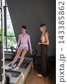 A detailed closeup of a foot work and core exercise on Body Reformer machine illuminated by sunlight.  143385862