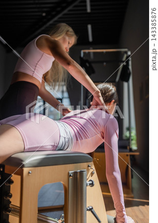 Women doing Swan exercise on Pilates Chair for the chest and back muscles, focusing on flexibility, strength, and control with determination Women doing Swan exercise on Pilates Chair for the chest and back muscles, focusing on flexibility, strength, and control with determination 143385876