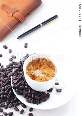 エスプレッソに牛乳をたっぷり入れたコーヒー、カフェ・ラッテと、深煎りしたコーヒー豆 エスプレッソに牛乳をたっぷり入れたコーヒー、カフェ・ラッテと、深煎りしたコーヒー豆 143387409