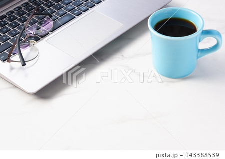 ノートパソコンでデスクワークの合間に、淹れたてのコーヒーでコーヒーブレイクを楽しんでいるイメージ 143388539