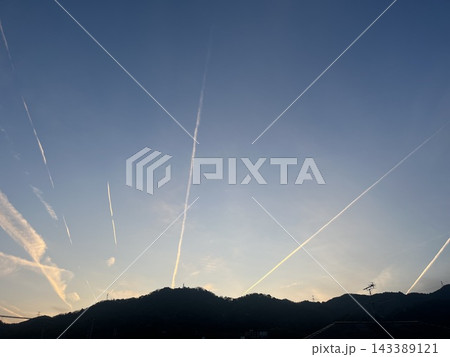山にかかる夕焼けの飛行機雲 143389121