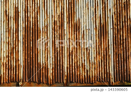 Texture or background of Rusted, aged galvanized sheet metal wall surface; weathered galvanized steel fence; retro concept; the artistry of old, rusty galvanized sheeting; vintage-style metal panels. Texture or background of Rusted, aged galvanized sheet metal wall surface; weathered galvanized steel fence; retro concept; the artistry of old, rusty galvanized sheeting; vintage-style metal panels. 143390605