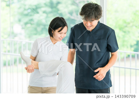 マッサージ,理学療法の研修を受ける若い女性スタッフと教える理学療法士の男性 マッサージ,理学療法の研修を受ける若い女性スタッフと教える理学療法士の男性 143390709